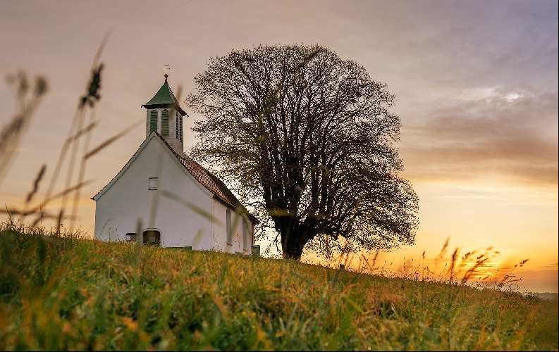 Church in a field at sunset